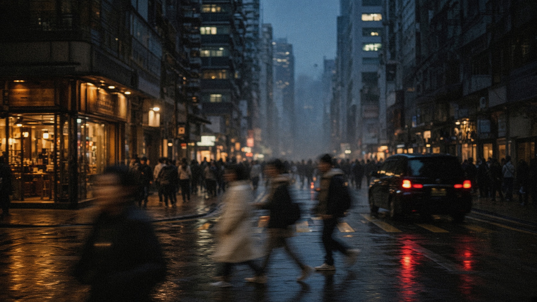 People moving through a city street at dusk